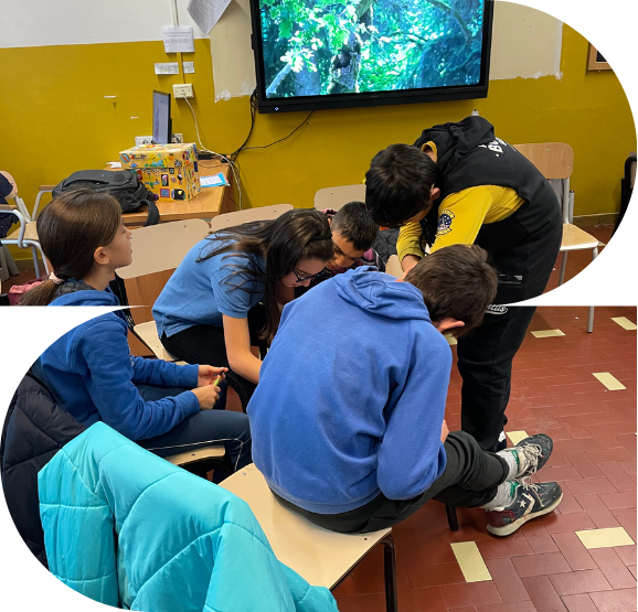 Immagine del laboratorio "Contrasto alla discriminazione economica" raffigurante un gruppo di ragazze e ragazzi adolescenti in classe che guardano interessate un dispositivo sedute e seduti su delle sedie