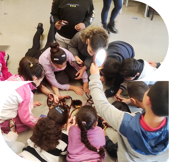 Immagine del laboratorio "Tutti diversi, tutti uguali" sull'educazione all'uguaglianza di genere condotta da Altrimodi raffigurante un gruppo classe tra i 6 e gli 11 anni seduto a terra che si guarda allo specchio (ciascuno all'interno di un suo piccolo specchio)